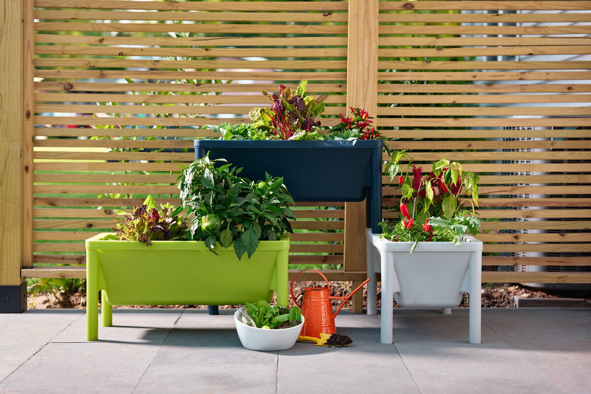 Three Harvi garden beds displayed in raised and stacked configurations on a small patio.
